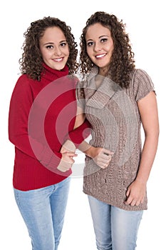 Happy girls: Portrait of real female twins wearing winter pullover.