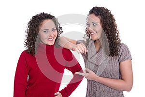 Happy girls: Portrait of real female twins wearing winter pullover.