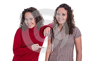 Happy girls: Portrait of real female twins wearing winter pullover.