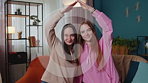 Happy girls siblings making roof gesture sign of hands, new home, ownership, insurance, bank loan