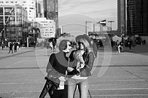 Happy girls walk in business district of La Defense, Paris