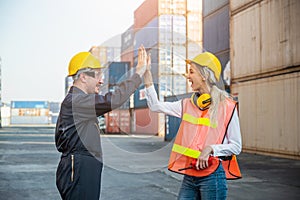 Happy giving hands two foreman man & woman worker working checking at Container cargo harbor to loading containers. Dock male and