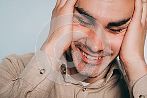 Happy glad joyous man laughing holding head hands