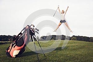 Happy golf player jumping on golf course.