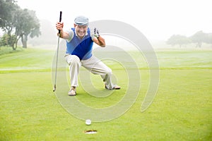 Happy golfer cheering on putting green