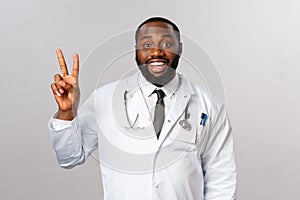 Happy good-looking, enthusiastic african american male doctor explain ways of treating patient disease, showing number