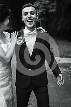 Happy gorgeous bride and stylish groom laughing and having fun. emotional moment of beautiful wedding couple. black white photo