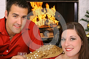 Happy gorgeous couple in front of fireplace