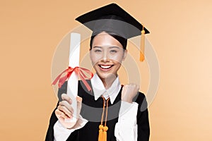 Happy Graduate asian woman in cap and gowm holding Certificated or diploma