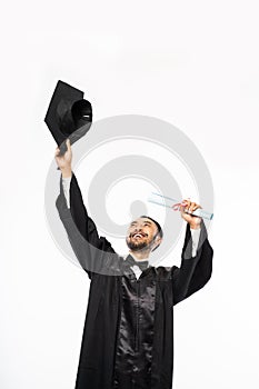 Happy graduate in black togas holding up toga hat