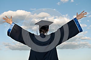 Happy graduate with risen arms