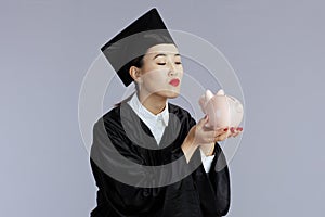 happy graduate student asian woman against gray