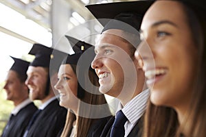 Happy graduates in mortars and gowns, head and shoulders