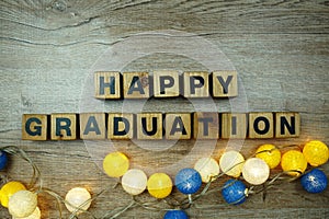 Happy Graduation alphabet letters with LED cotton balls decoration on wooden background