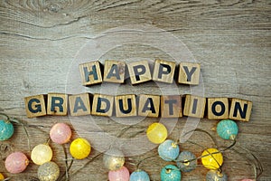 Happy Graduation alphabet letters with LED cotton balls decoration on wooden background