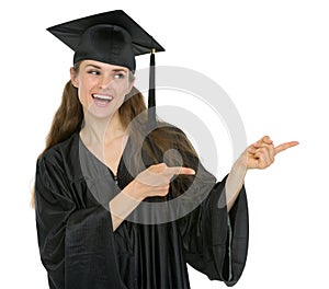 Happy graduation student girl pointing sideways