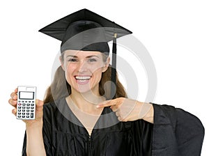 Happy graduation student pointing on calculator