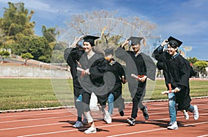 Happy graduation students  holding diploma and running on the stadium at school