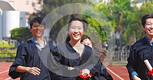 Happy graduation students  holding diploma and running on the stadium at school