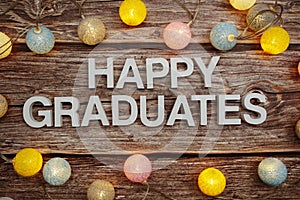 Happy Graduation text with LED cotton balls decoration on wooden background