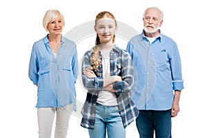 Happy grandchild standing with grandfather and grandmother behind