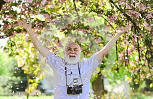 Happy grandfather. Capturing beauty life journey. Photographer in blooming garden. Sakura petals falling down. Vintage