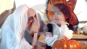 Happy Grandfather and child boy in Halloween Costume. Scary stories. Man and boy scare guests. Halloween at home.