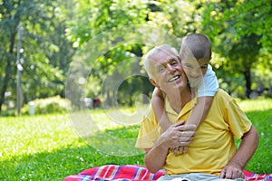 Happy grandfather and child in park