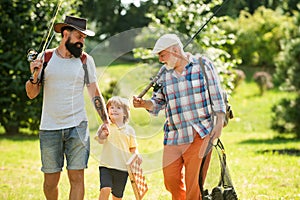 Happy grandfather, father and grandson with fishing rods. Anglers. Men day. Grandfather, father and son are fishing.