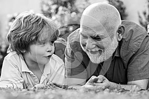 Happy grandfather and grandson relaxing together. Fathers day. Cute boy with dad playing outdoor. Two different