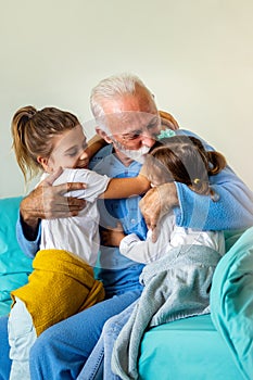 Happy grandfather and his grandchildren laughing and enjoying leisure time together.