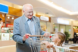 Happy grandfather and kid are shopping together.