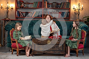 Happy grandma and grandchildren reading book together at home