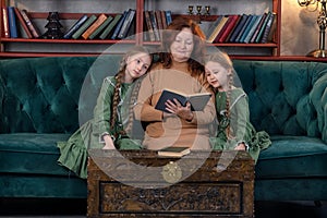 Happy grandma and grandchildren reading book together at home