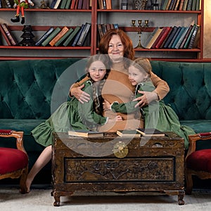 Happy grandma and grandchildren reading book together at home