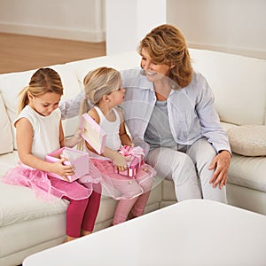 Happy, grandmother and children with present for birthday, surprise and opening on sofa or living room at home. Happy
