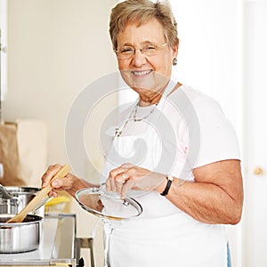 Happy grandmother cooking in kitchen