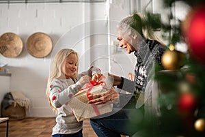 Grandmother giving xmas present to granddaughter