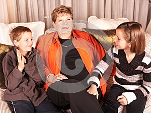 Happy grandmother and grandchildren on sofa