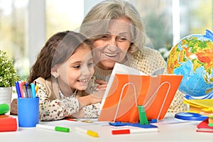 Happy Grandmother with granddaughter drawing together