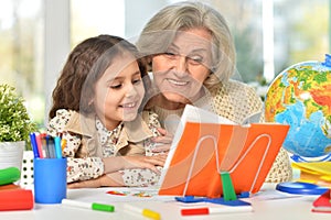 Happy Grandmother with granddaughter drawing together