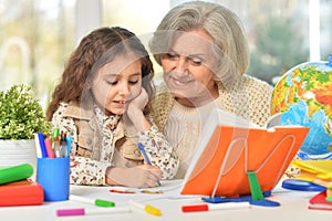 Happy Grandmother with granddaughter drawing together