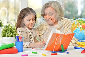 Happy Grandmother with granddaughter drawing together