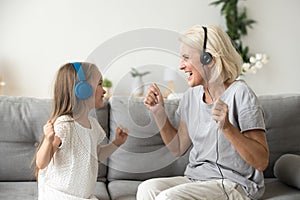 Happy grandmother and granddaughter listening to music in headph