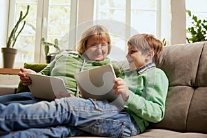 Happy grandmother and grandson spending time together at home. Concept of emotions, family, happiness, care, support and