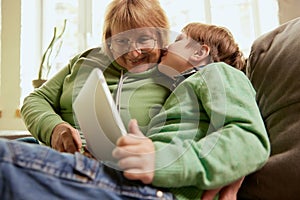 Happy grandmother and grandson spending time together at home. Concept of emotions, family, happiness, care, support and
