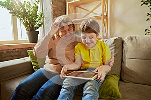 Happy grandmother and grandson spending time together at home. Concept of emotions, family, happiness, care, support and