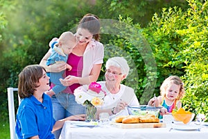 Happy grandmother having lunch with her family