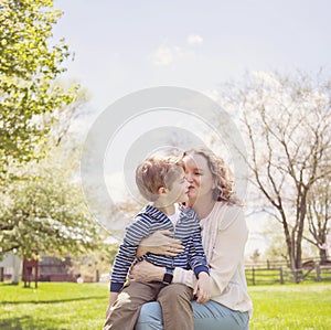 Happy Grandmother kissing grandson in park