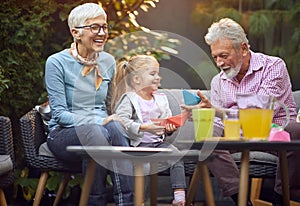 Happy grandparents playing  with  granddaughter. Family generations concept